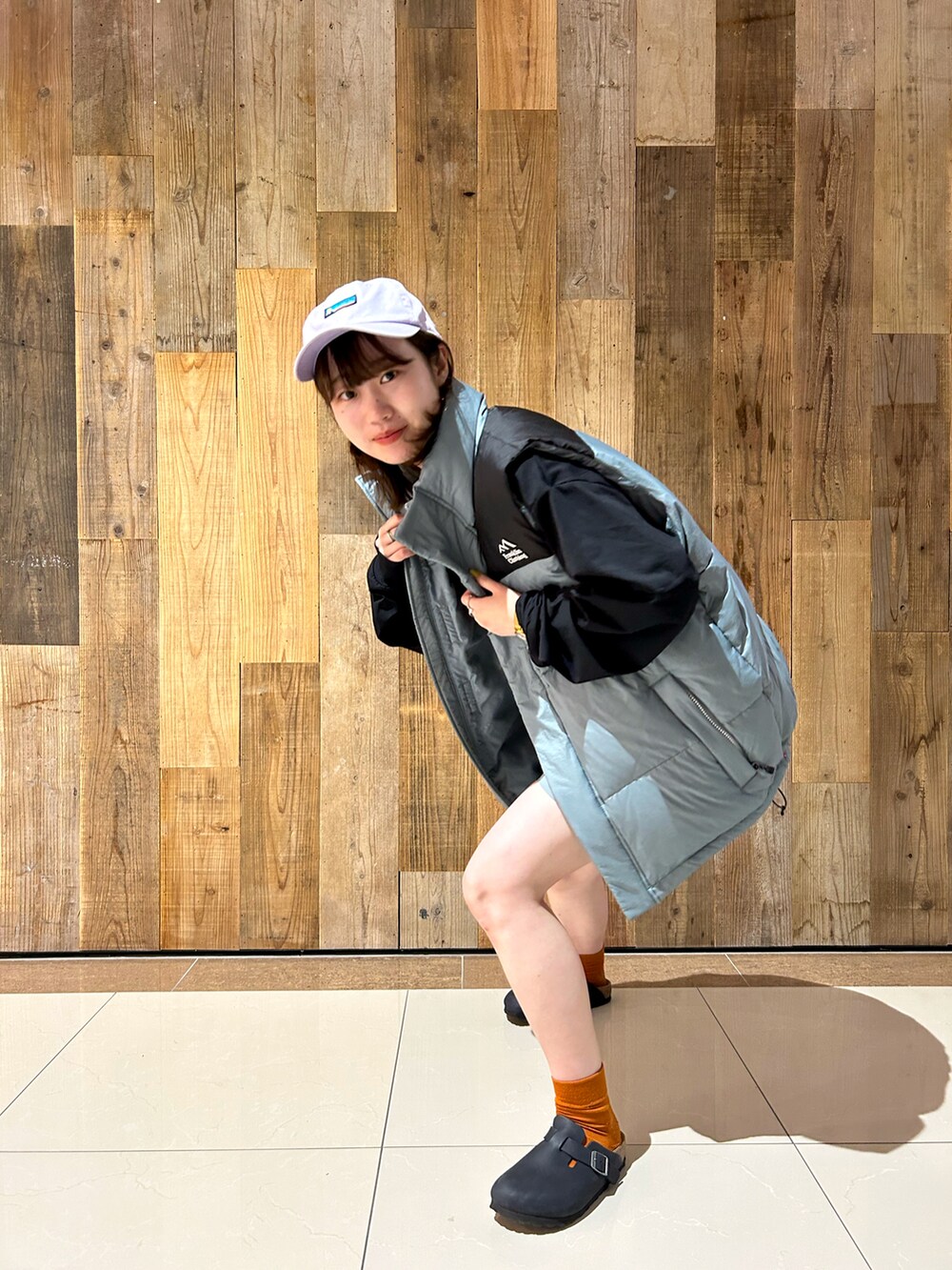 ブラック系のTシャツ/カットソー、ブルー系のダウンベスト、ベージュ系のその他パンツを着用したレディースの秋コーディネートの3枚目の写真