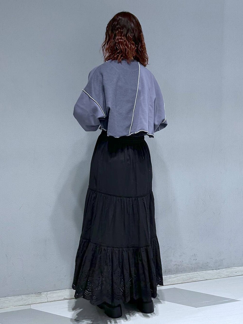 ブルー系のスウェット、ブラック系のスカート、ブラウン系のブルゾンを着用したレディースの冬コーディネートの6枚目の写真