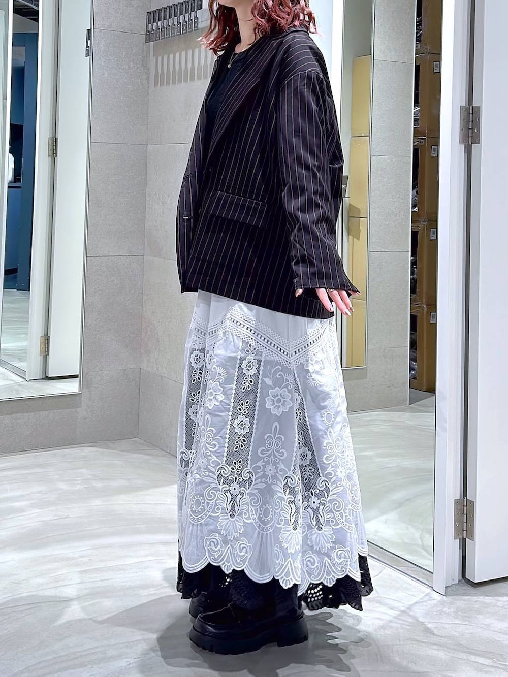 ブラック系のローファー、ブラック系のテーラードジャケット、ホワイト系のスカートを着用したレディースの冬コーディネートの3枚目の写真