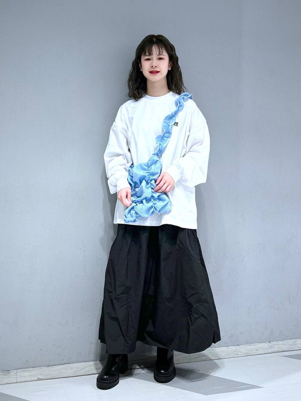 ホワイト系のTシャツ/カットソー、ブルー系のショルダーバッグ、ブラック系のスカートを着用したレディースの春コーディネートの5枚目の写真