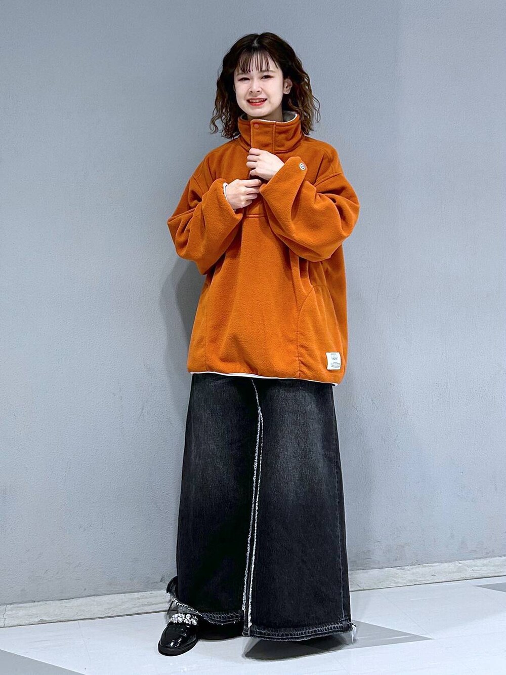 ブラック系のデニムスカート、オレンジ系のスウェットを着用したレディースの秋コーディネートの4枚目の写真