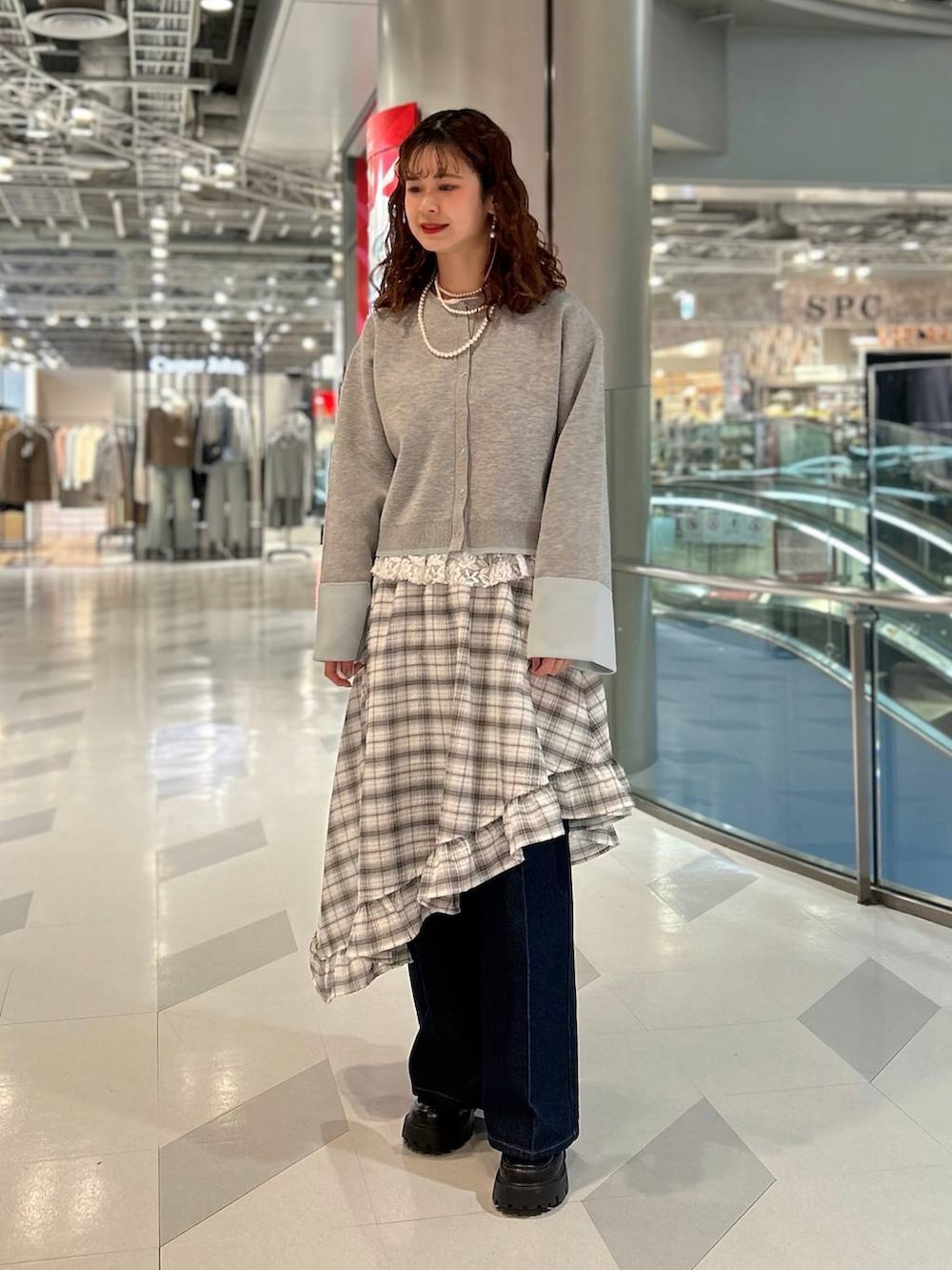 ブラック系のローファー、ブルー系のデニムパンツ、グレー系のカーディガン/ボレロを着用したレディースの冬コーディネートの3枚目の写真