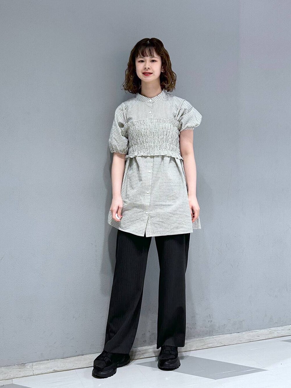 ブラック系のスラックス、ホワイト系のシャツ/ブラウス、ブラック系のサンダルを着用したレディースの夏コーディネートの4枚目の写真