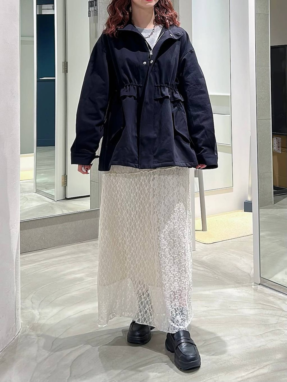 ブラック系のローファー、ホワイト系のスカート、グレー系のスウェットを着用したレディースの春コーディネートの2枚目の写真