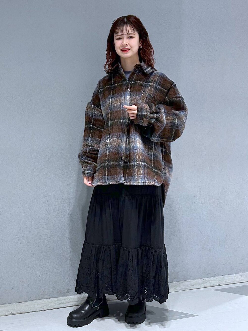 ブルー系のスウェット、ブラック系のスカート、ブラウン系のブルゾンを着用したレディースの冬コーディネートの5枚目の写真