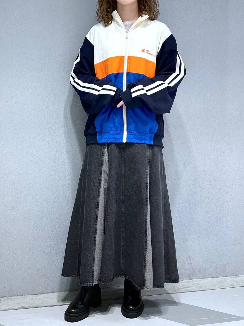 グレー系のTシャツ/カットソー、ホワイト系のブルゾン、ブラック系のデニムスカートを着用したレディースの春コーディネートの2枚目の写真