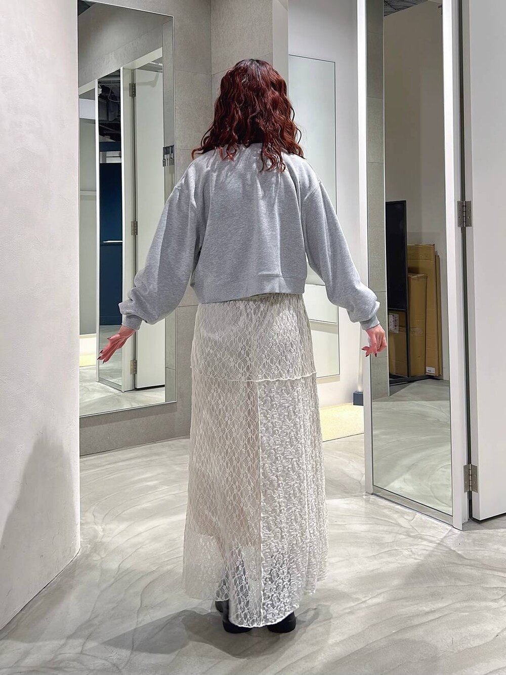 ブラック系のローファー、ホワイト系のスカート、グレー系のスウェットを着用したレディースの春コーディネートの5枚目の写真