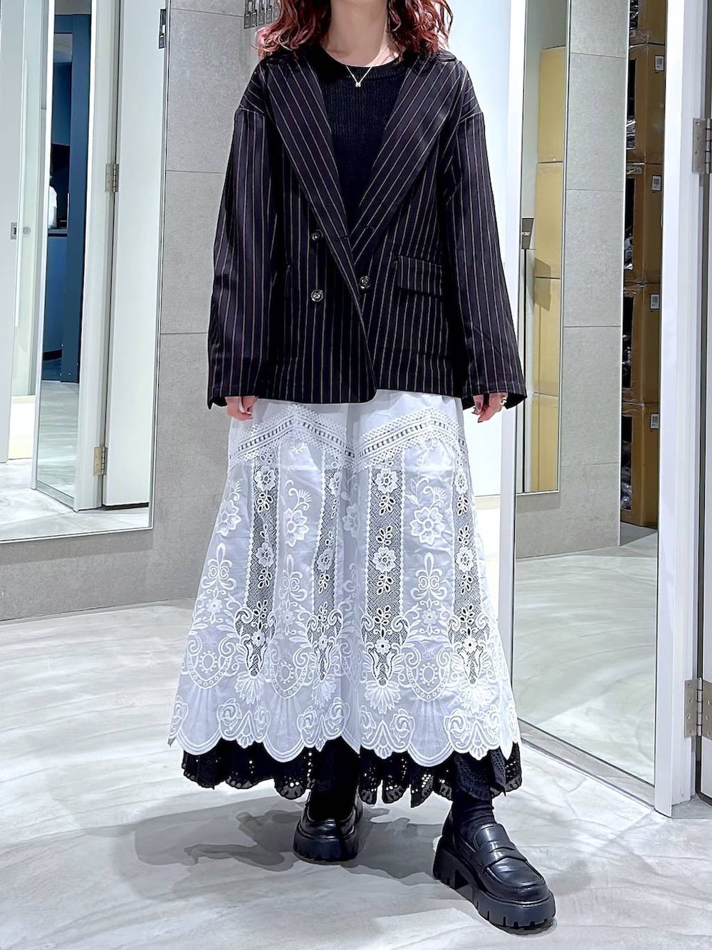 ブラック系のローファー、ブラック系のテーラードジャケット、ホワイト系のスカートを着用したレディースの冬コーディネートの2枚目の写真