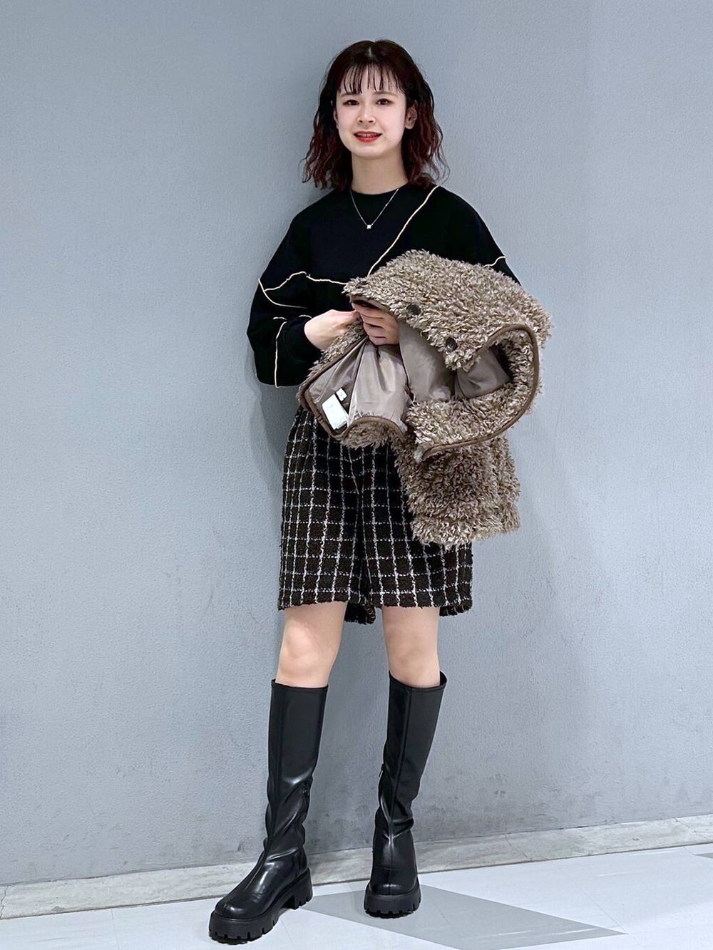 ブラック系のブーツ、ブラック系のスウェット、ベージュ系のブルゾンを着用したレディースの秋コーディネートの2枚目の写真