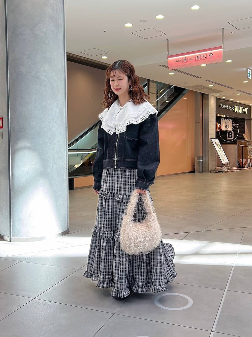 ホワイト系のシャツ/ブラウス、ブラック系のスカート、ブラック系のデニムジャケットを着用したレディースの冬コーディネートの3枚目の写真