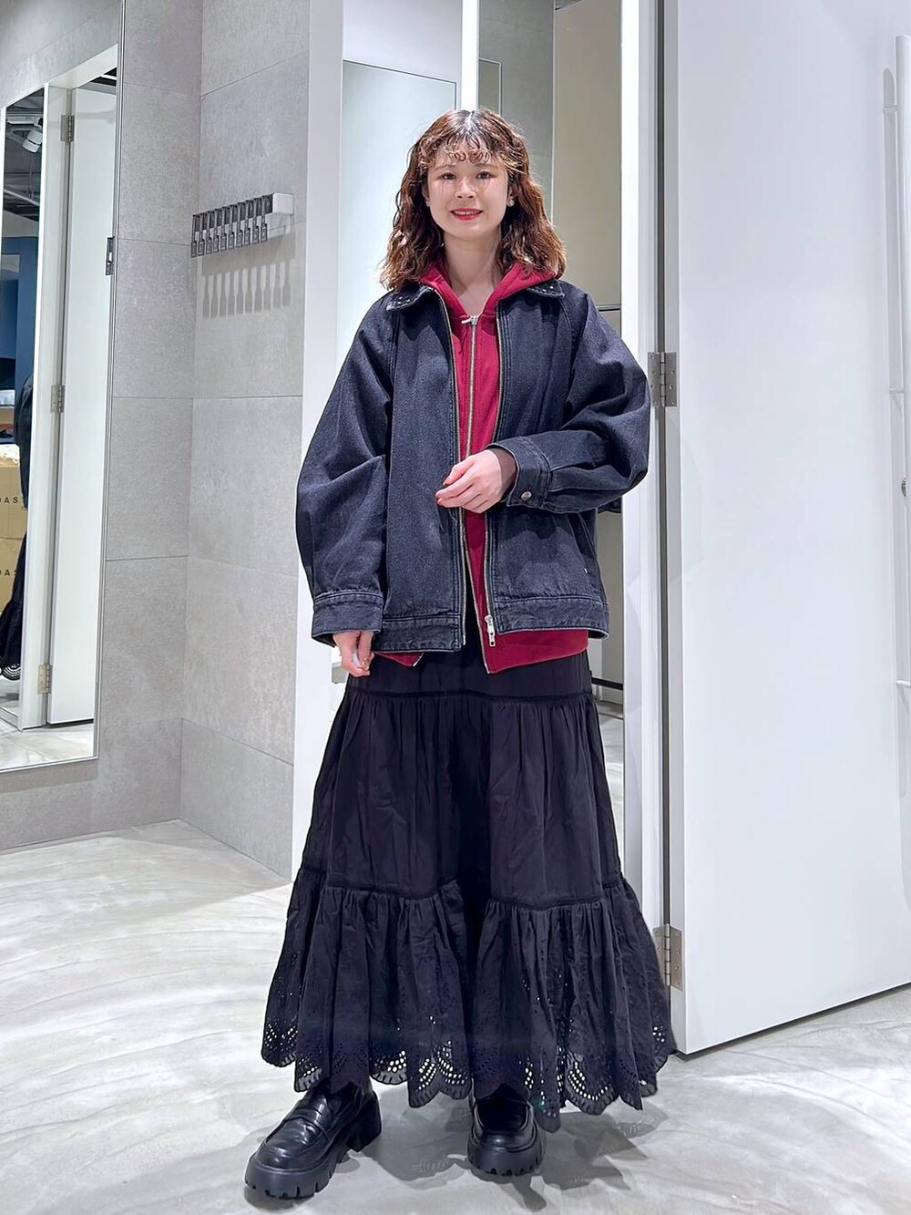 ブラック系のローファー、ブラック系のブルゾン、レッド系のパーカーを着用したレディースの秋コーディネートの4枚目の写真