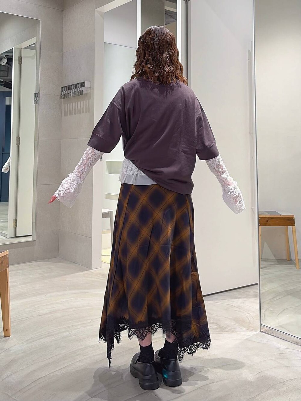 グレー系のスカート、ホワイト系のTシャツ/カットソー、ブラック系のローファーを着用したレディースの夏コーディネートの4枚目の写真
