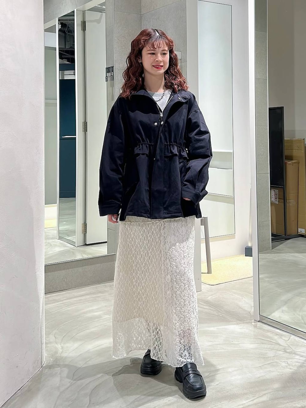 ブラック系のローファー、ホワイト系のスカート、グレー系のスウェットを着用したレディースの春コーディネートの4枚目の写真