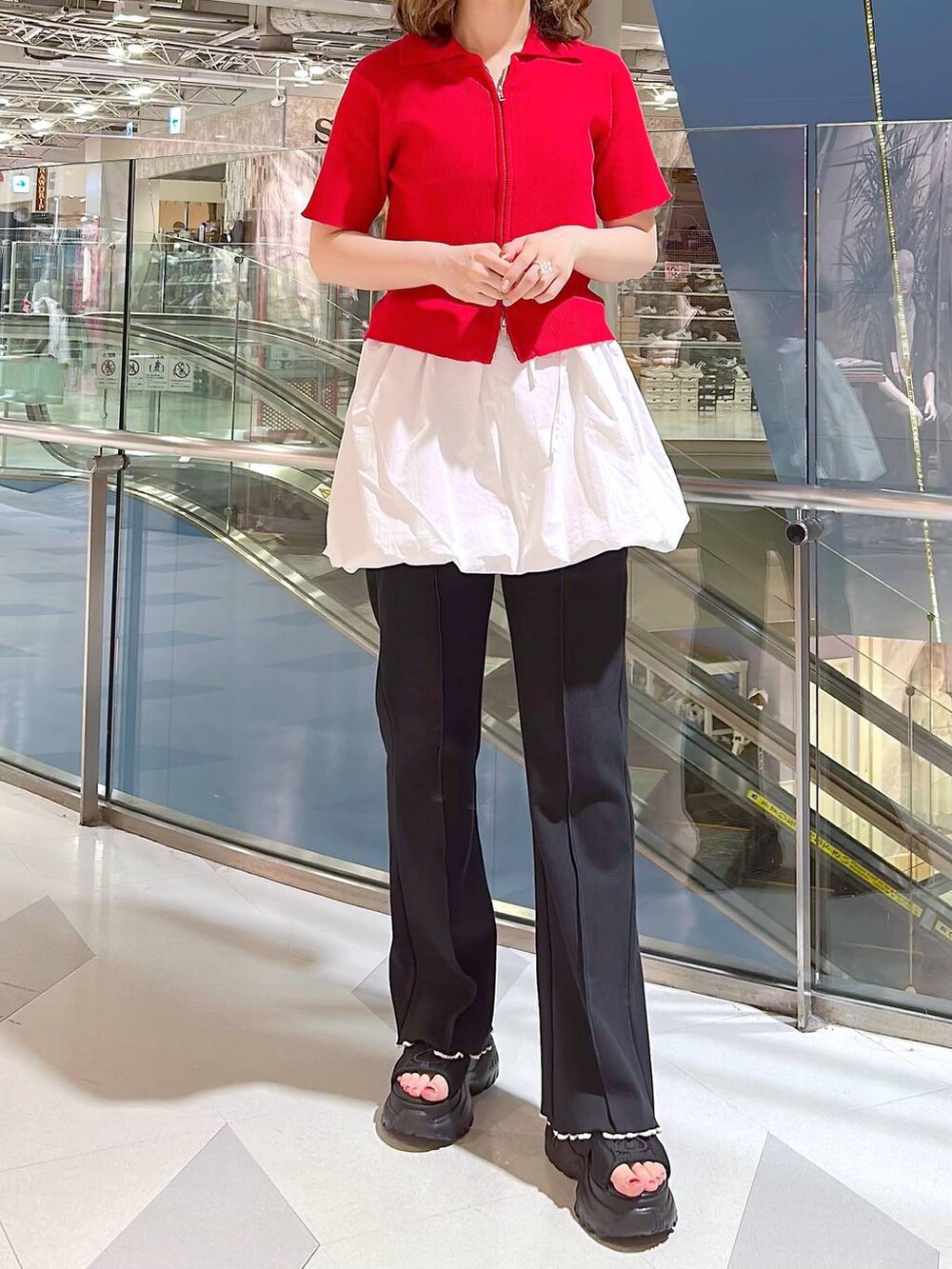 ブラック系のサンダル、レッド系のニット/セーター、ホワイト系のワンピースを着用したレディースの夏コーディネートの2枚目の写真