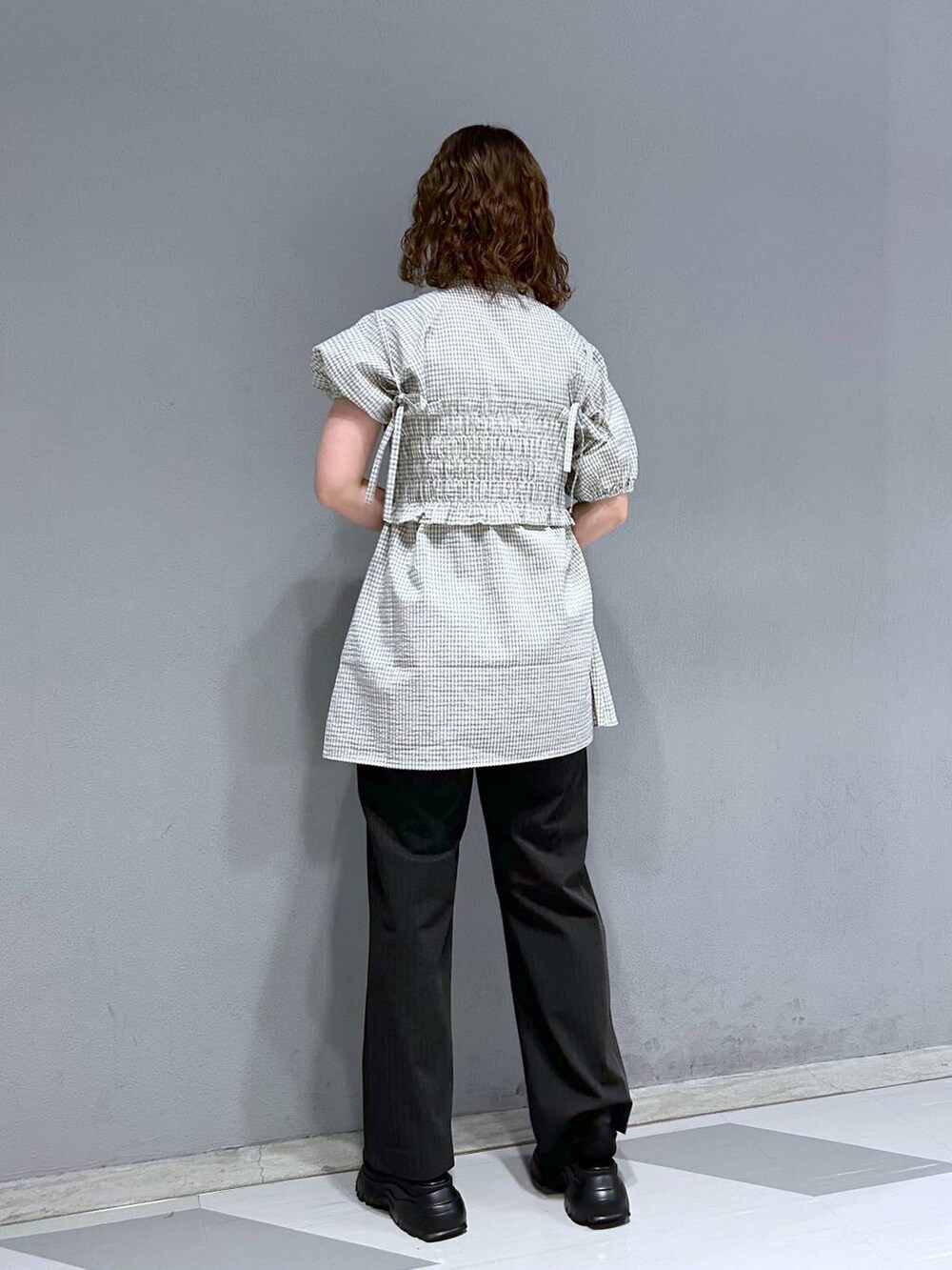 ブラック系のスラックス、ホワイト系のシャツ/ブラウス、ブラック系のサンダルを着用したレディースの夏コーディネートの5枚目の写真