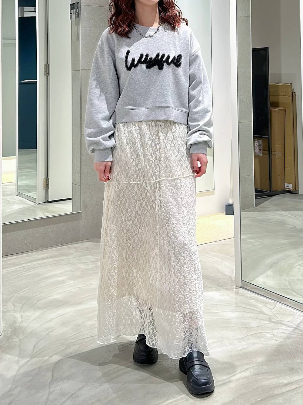 ブラック系のローファー、ホワイト系のスカート、グレー系のスウェットを着用したレディースの春コーディネートの2枚目の写真