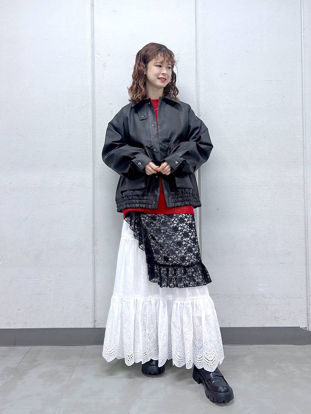 ブラック系のローファー、ブラック系のブルゾン、レッド系のニット/セーターを着用したレディースの秋コーディネートの3枚目の写真