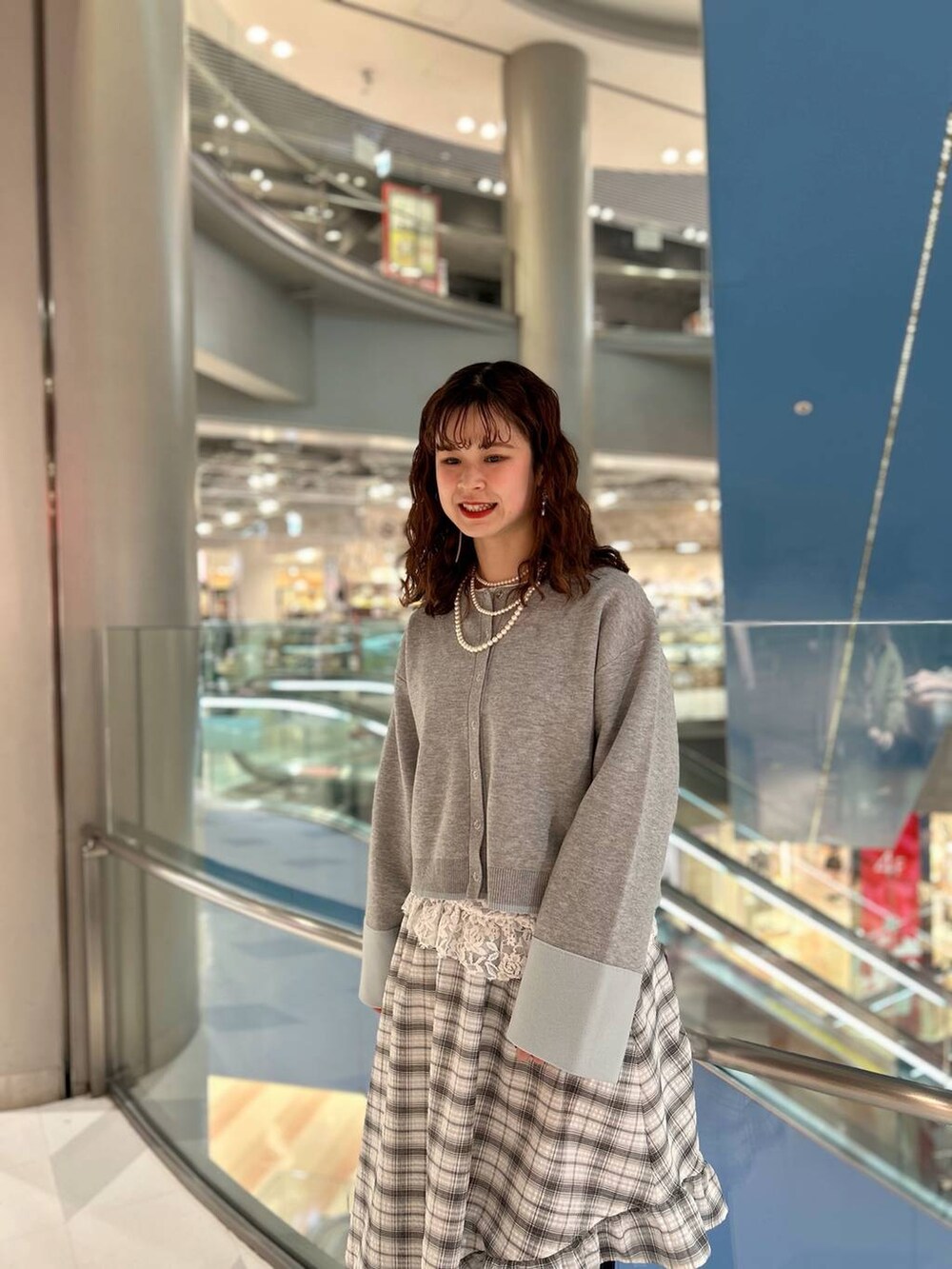 ブラック系のローファー、ブルー系のデニムパンツ、グレー系のカーディガン/ボレロを着用したレディースの冬コーディネートの2枚目の写真