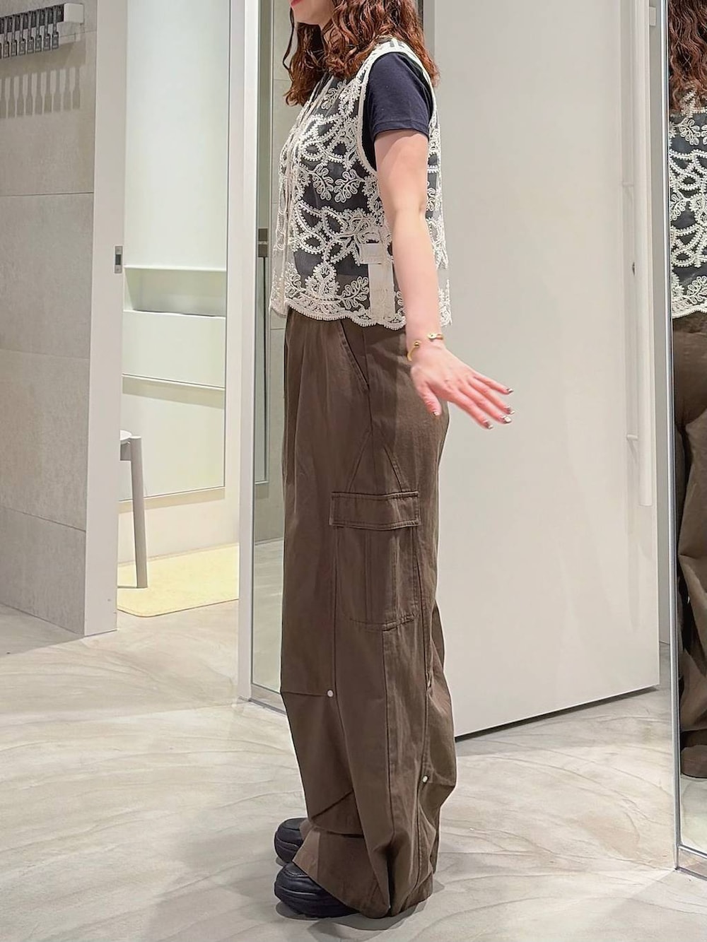 グリーン系のカーゴパンツ、ホワイト系のベスト、ブラック系のローファーを着用したレディースの夏コーディネートの4枚目の写真