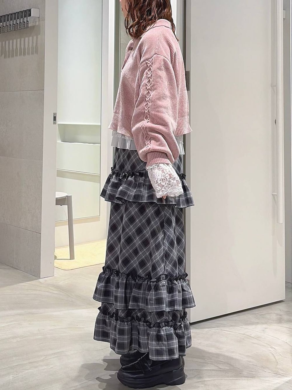 ピンク系のニット/セーター、ホワイト系のTシャツ/カットソー、ブラック系のスカートを着用したレディースの秋コーディネートの4枚目の写真