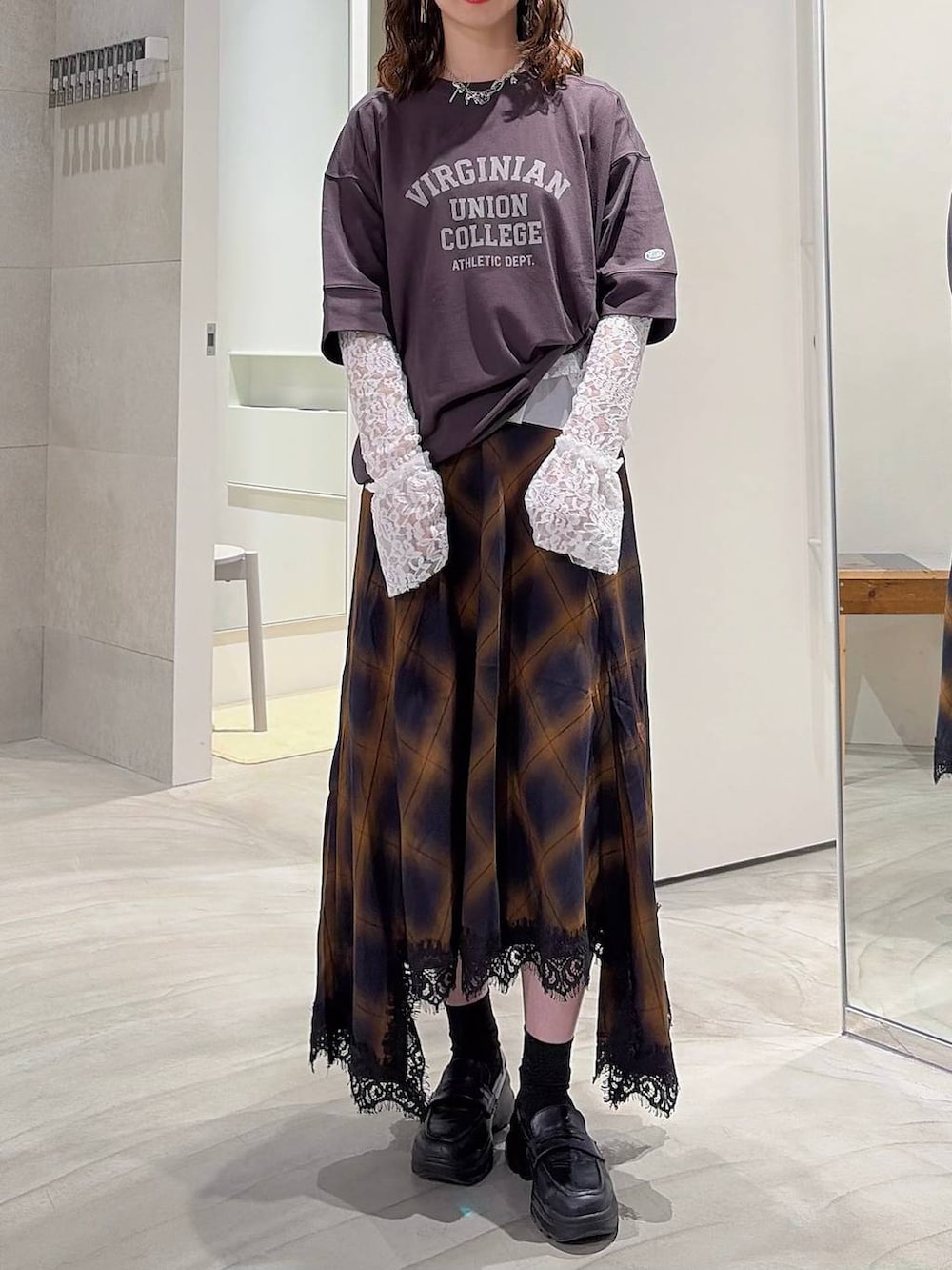 グレー系のスカート、ホワイト系のTシャツ/カットソー、ブラック系のローファーを着用したレディースの夏コーディネートの2枚目の写真