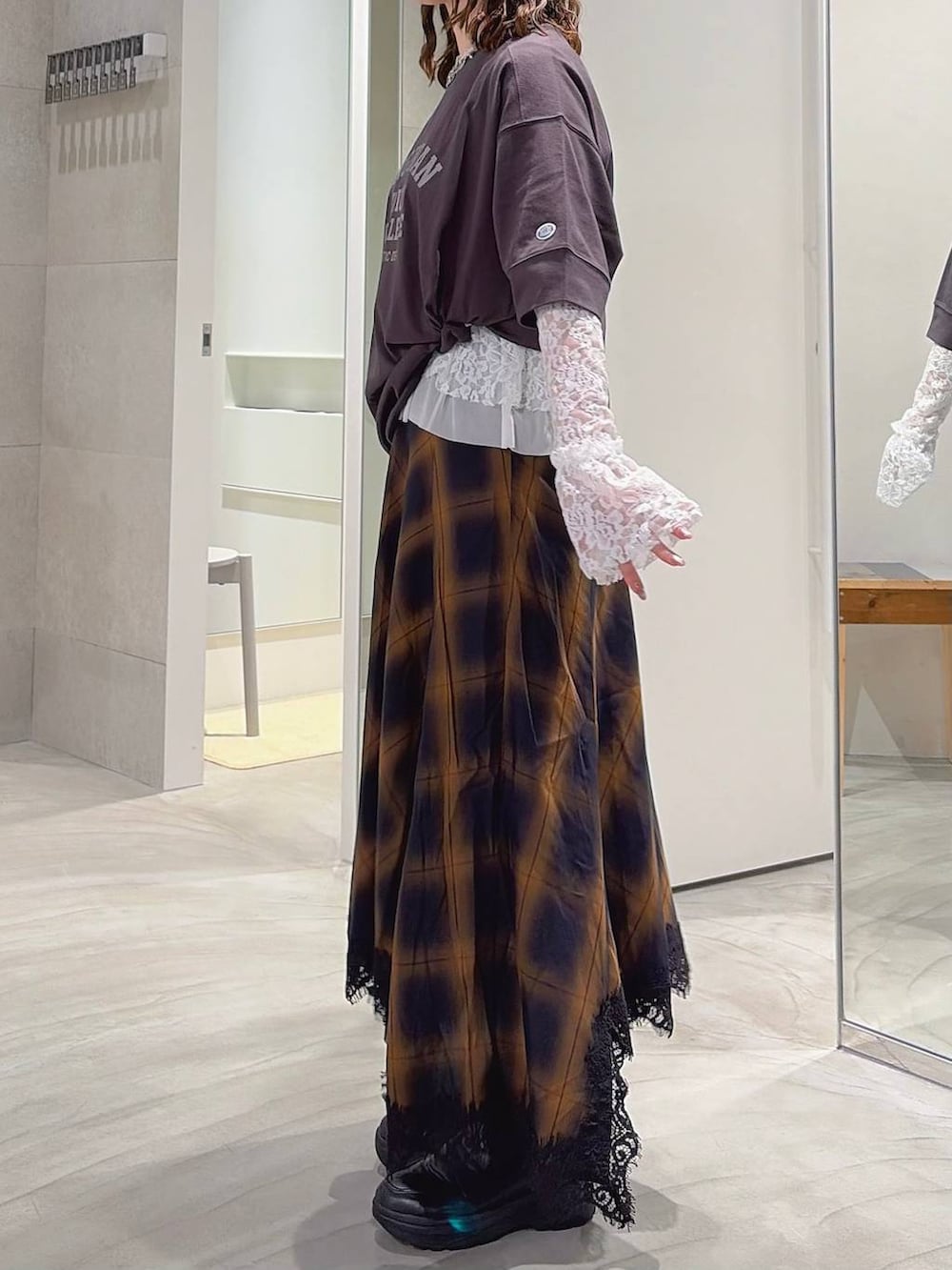 グレー系のスカート、ホワイト系のTシャツ/カットソー、ブラック系のローファーを着用したレディースの夏コーディネートの3枚目の写真