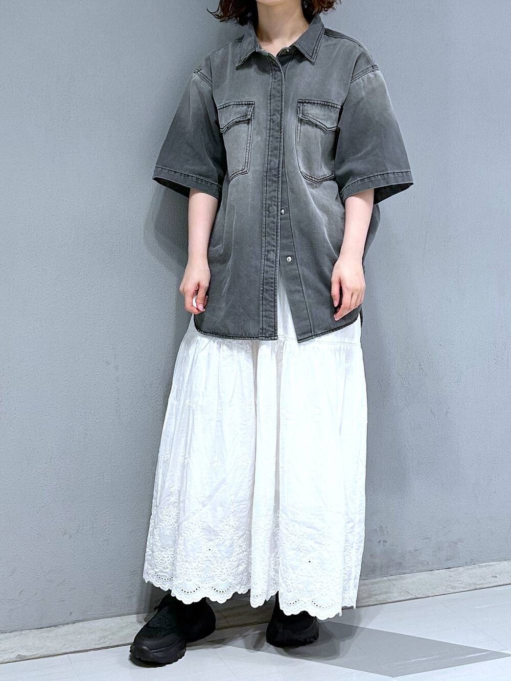 ホワイト系のスカート、グレー系のシャツ/ブラウスを着用したレディースの夏コーディネートの2枚目の写真