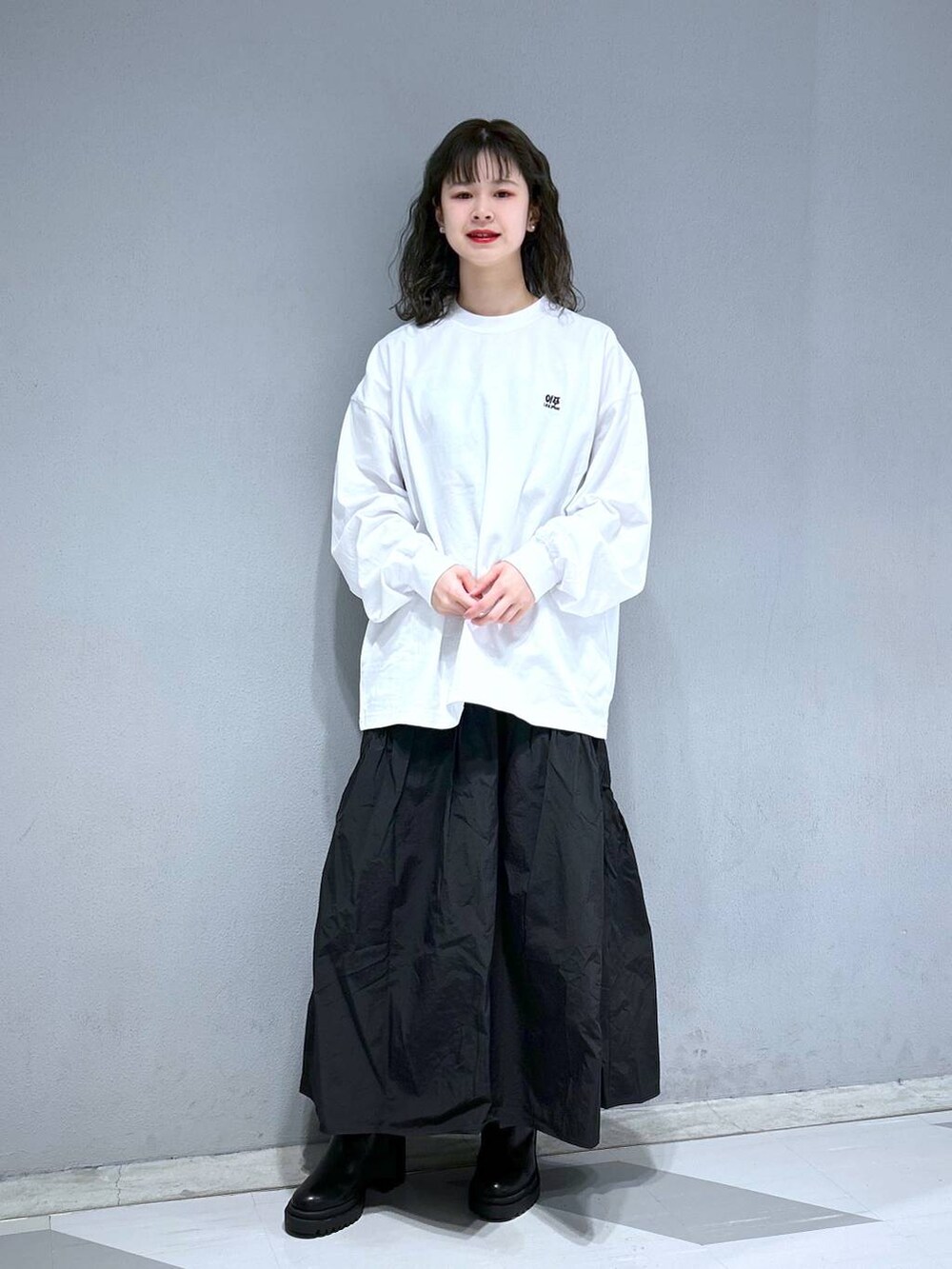 ホワイト系のTシャツ/カットソー、ブルー系のショルダーバッグ、ブラック系のスカートを着用したレディースの春コーディネートの2枚目の写真