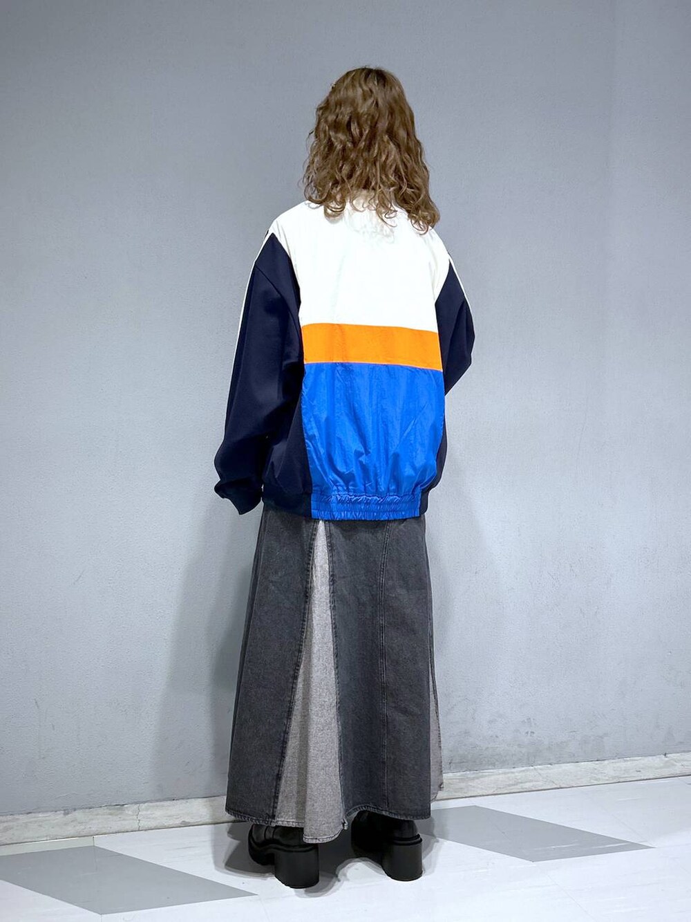 グレー系のTシャツ/カットソー、ホワイト系のブルゾン、ブラック系のデニムスカートを着用したレディースの春コーディネートの4枚目の写真