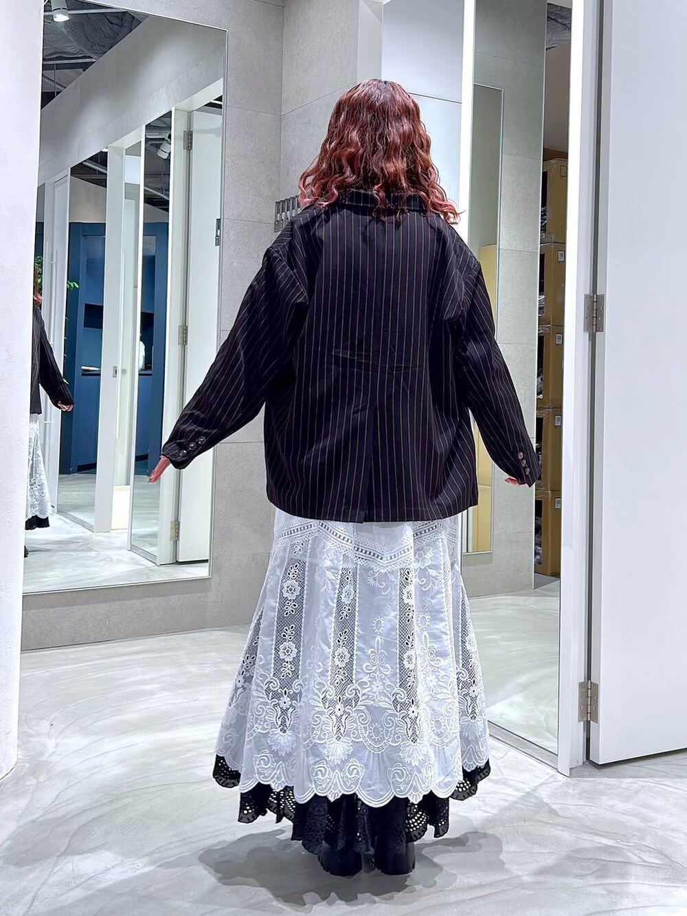 ブラック系のローファー、ブラック系のテーラードジャケット、ホワイト系のスカートを着用したレディースの冬コーディネートの5枚目の写真