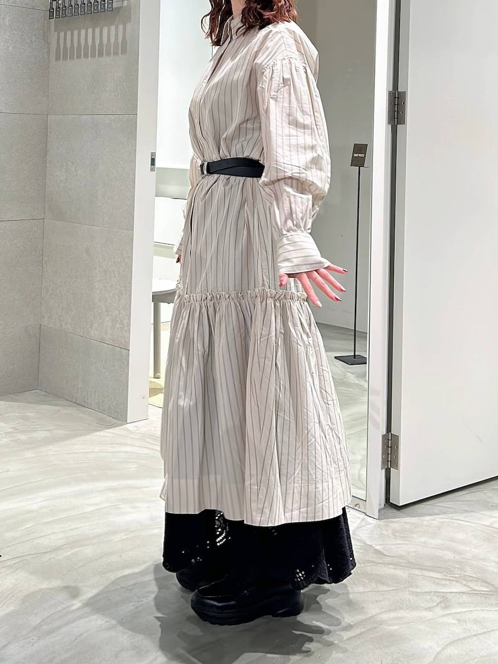 ブラック系のローファー、ベージュ系のシャツワンピース、ブラック系のスカートを着用したレディースの春コーディネートの3枚目の写真