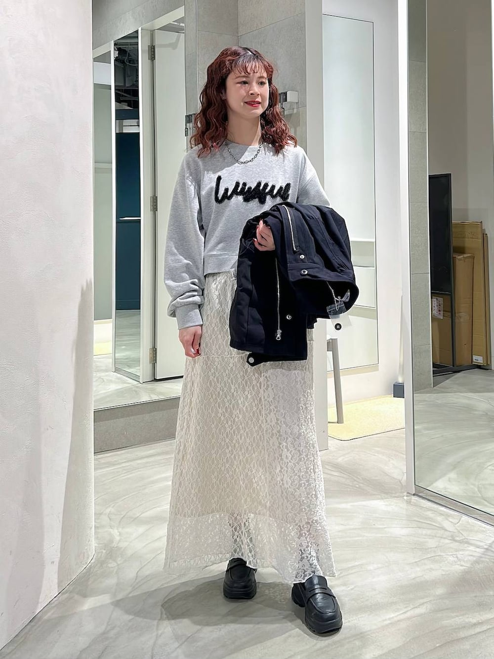 ブラック系のローファー、ホワイト系のスカート、グレー系のスウェットを着用したレディースの春コーディネートの5枚目の写真