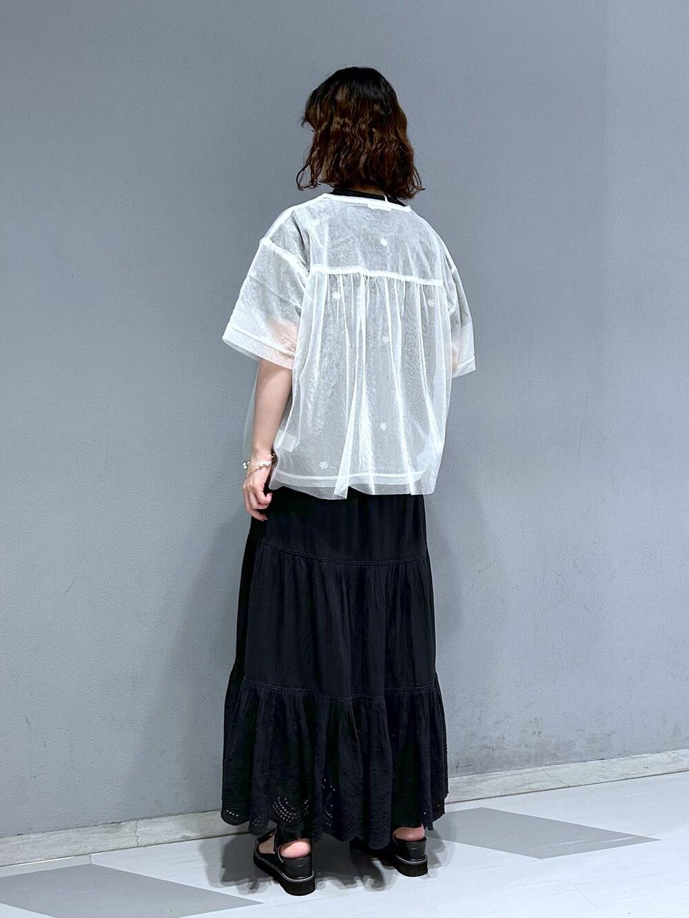 ブラック系のスカート、ホワイト系のTシャツ/カットソー、ブラック系のTシャツ/カットソーを着用したレディースの夏コーディネートの5枚目の写真