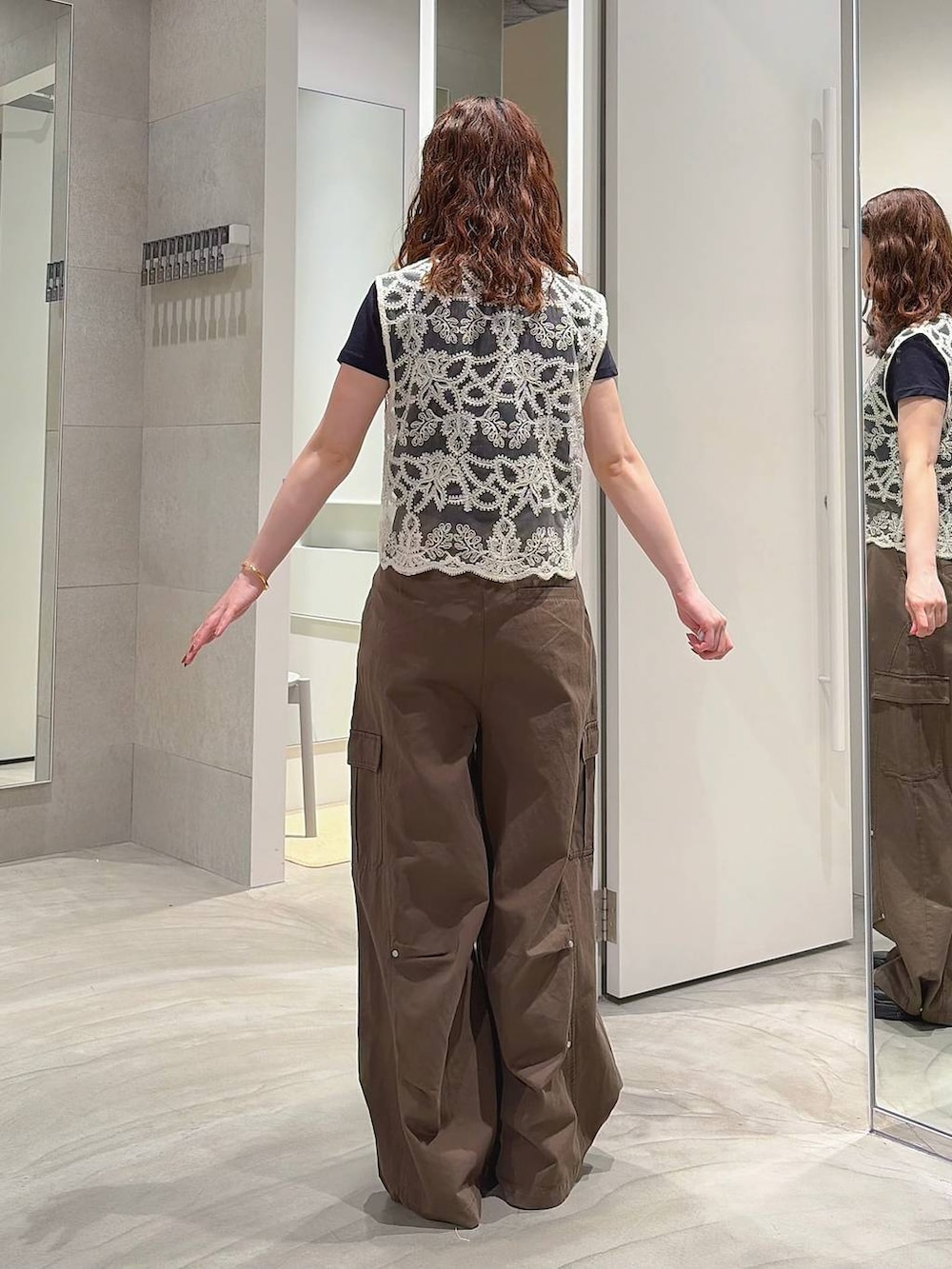 グリーン系のカーゴパンツ、ホワイト系のベスト、ブラック系のローファーを着用したレディースの夏コーディネートの5枚目の写真