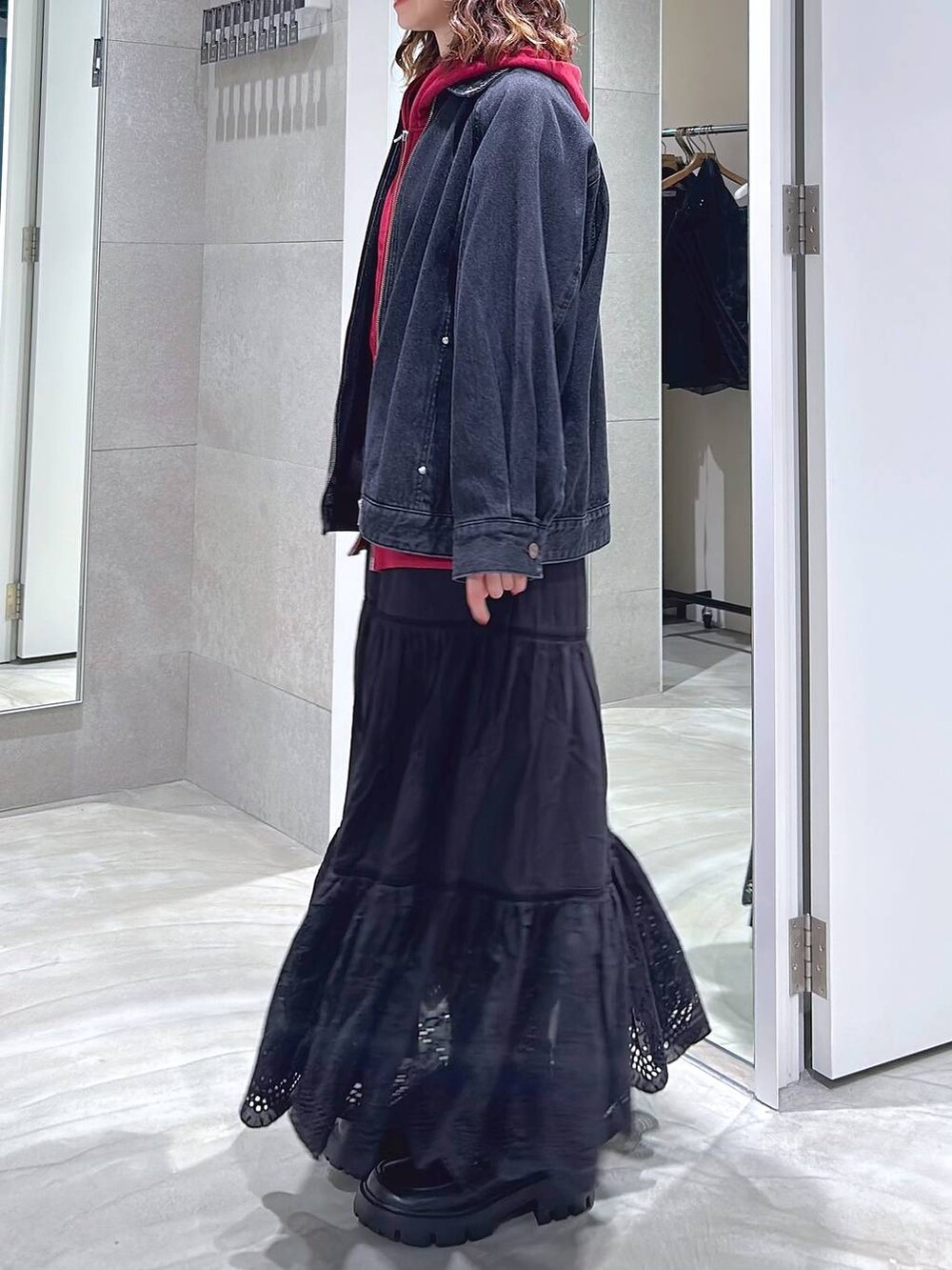 ブラック系のローファー、ブラック系のブルゾン、レッド系のパーカーを着用したレディースの秋コーディネートの3枚目の写真