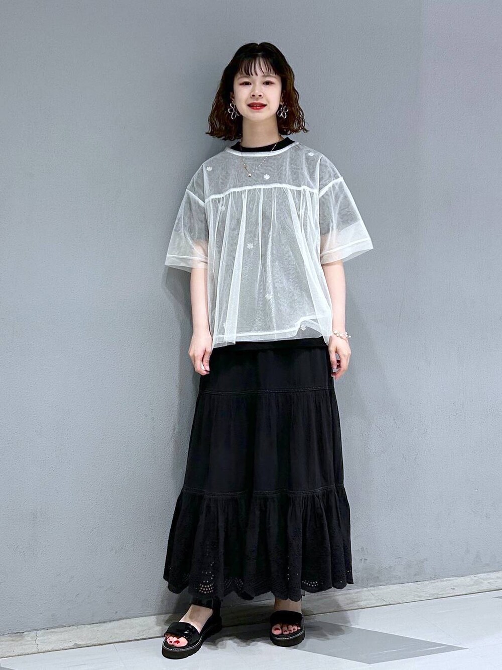 ブラック系のスカート、ホワイト系のTシャツ/カットソー、ブラック系のTシャツ/カットソーを着用したレディースの夏コーディネートの4枚目の写真