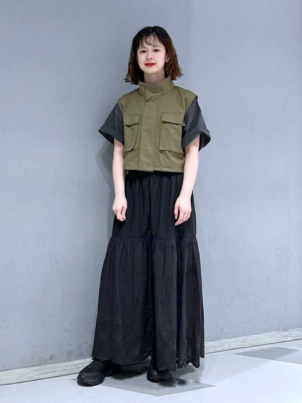 ブラック系のスカート、グリーン系のベスト、ブラック系のTシャツ/カットソーを着用したレディースの夏コーディネートの4枚目の写真