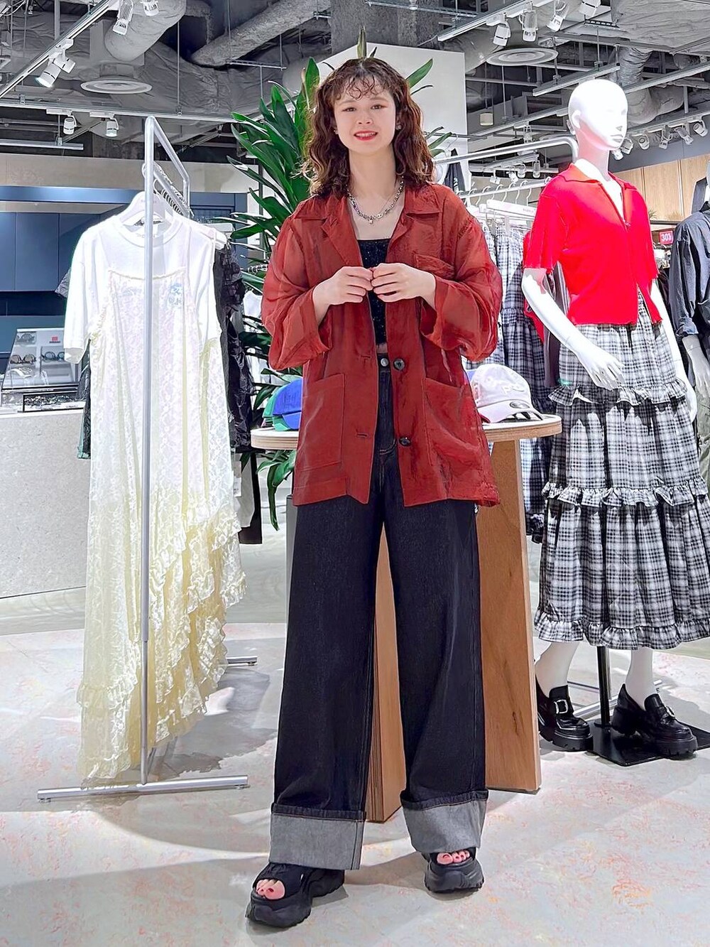 ブラック系のデニムパンツ、ブラック系のベスト、ブラック系のサンダルを着用したレディースの秋コーディネートの4枚目の写真