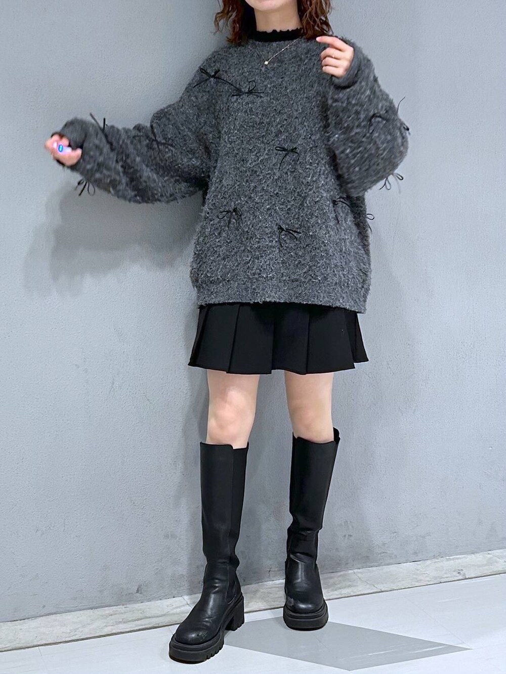 グレー系のニット/セーターを着用したレディースの冬コーディネートの2枚目の写真