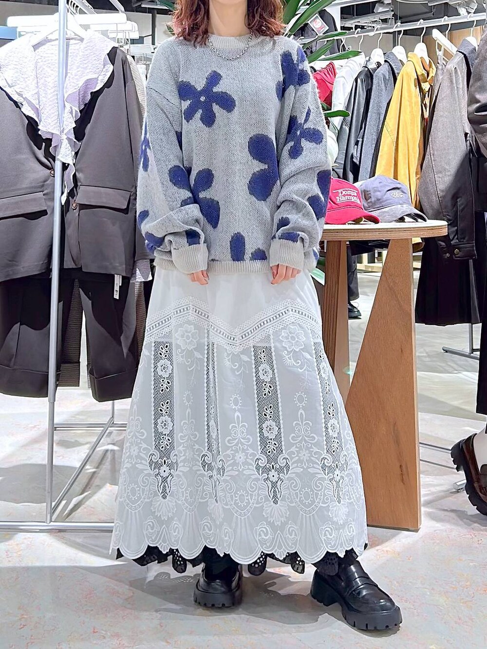 ブラック系のローファー、ホワイト系のニット/セーター、ブラック系のスカートを着用したレディースの秋コーディネートの2枚目の写真