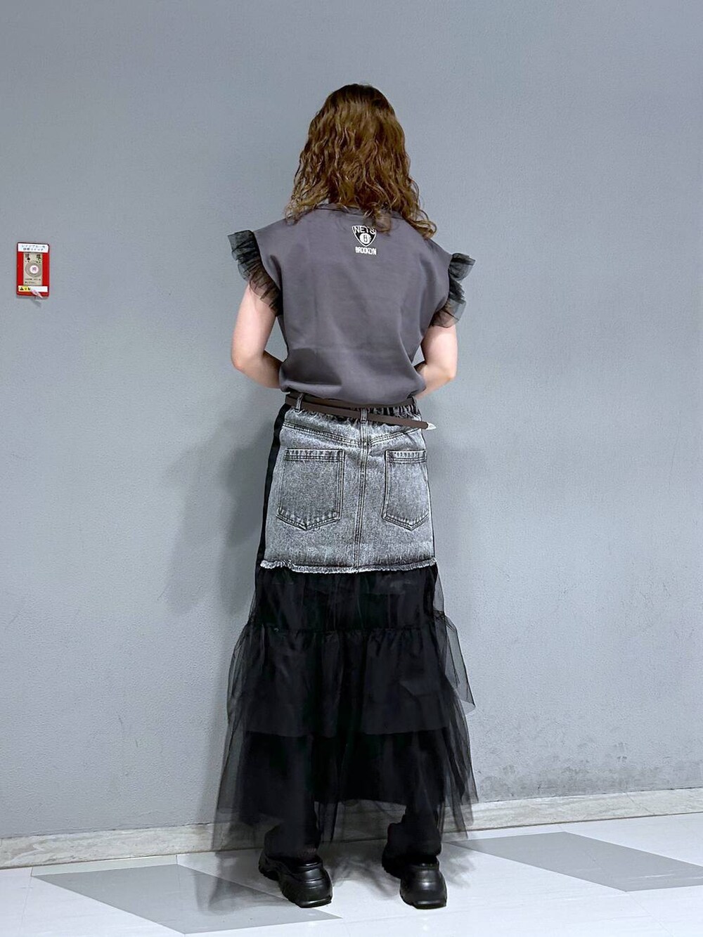 ブラック系のTシャツ/カットソー、ブラック系のデニムスカート、ブラウン系のベルトを着用したレディースの春コーディネートの5枚目の写真