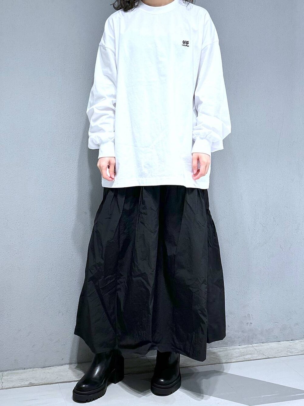 ホワイト系のTシャツ/カットソー、ブルー系のショルダーバッグ、ブラック系のスカートを着用したレディースの春コーディネートの3枚目の写真