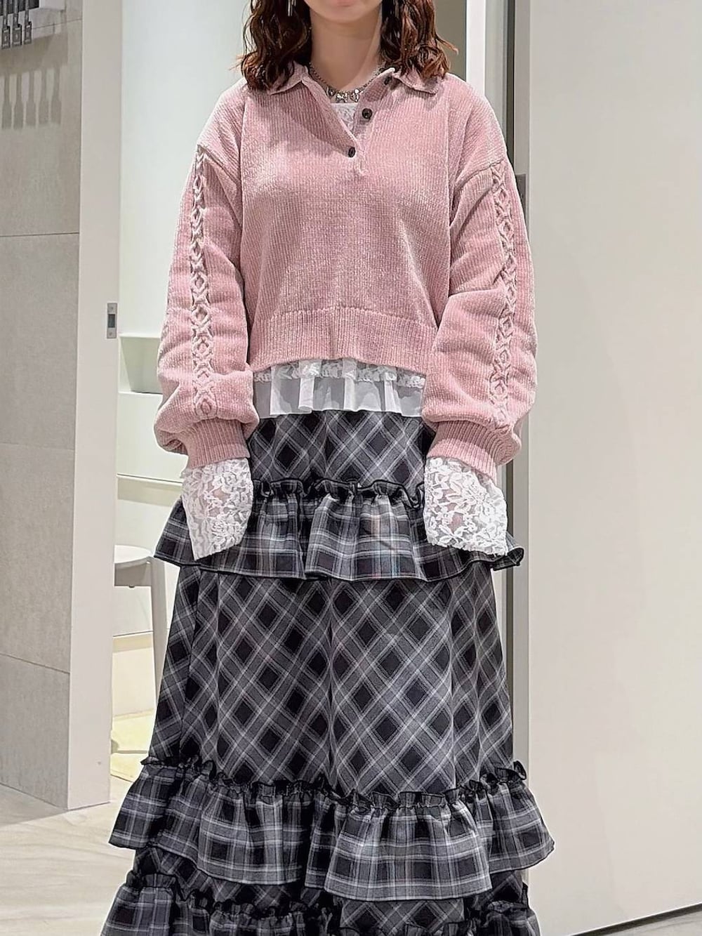 ピンク系のニット/セーター、ホワイト系のTシャツ/カットソー、ブラック系のスカートを着用したレディースの秋コーディネートの3枚目の写真