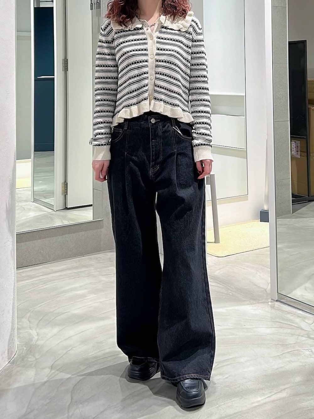 ブラック系のローファー、ブラック系のデニムパンツ、ホワイト系のカーディガン/ボレロを着用したレディースの春コーディネートの2枚目の写真