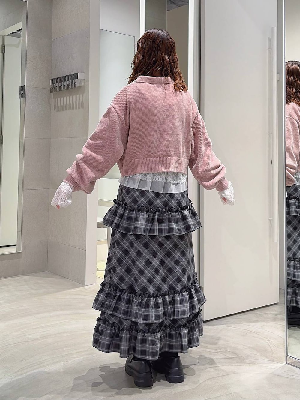 ピンク系のニット/セーター、ホワイト系のTシャツ/カットソー、ブラック系のスカートを着用したレディースの秋コーディネートの5枚目の写真