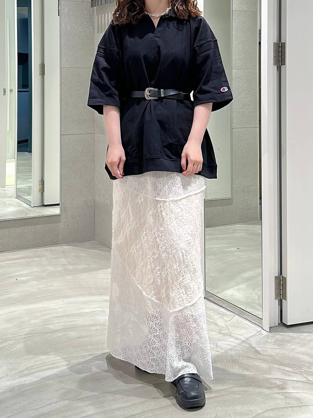 ブラック系のローファー、ブラック系のTシャツ/カットソー、ホワイト系のスカートを着用したレディースの夏コーディネートの2枚目の写真