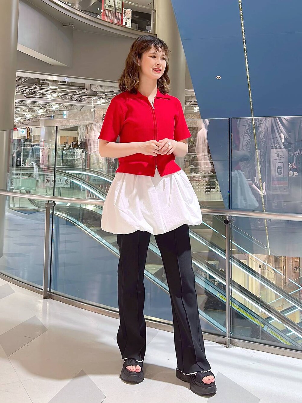 ブラック系のサンダル、レッド系のニット/セーター、ホワイト系のワンピースを着用したレディースの夏コーディネートの3枚目の写真