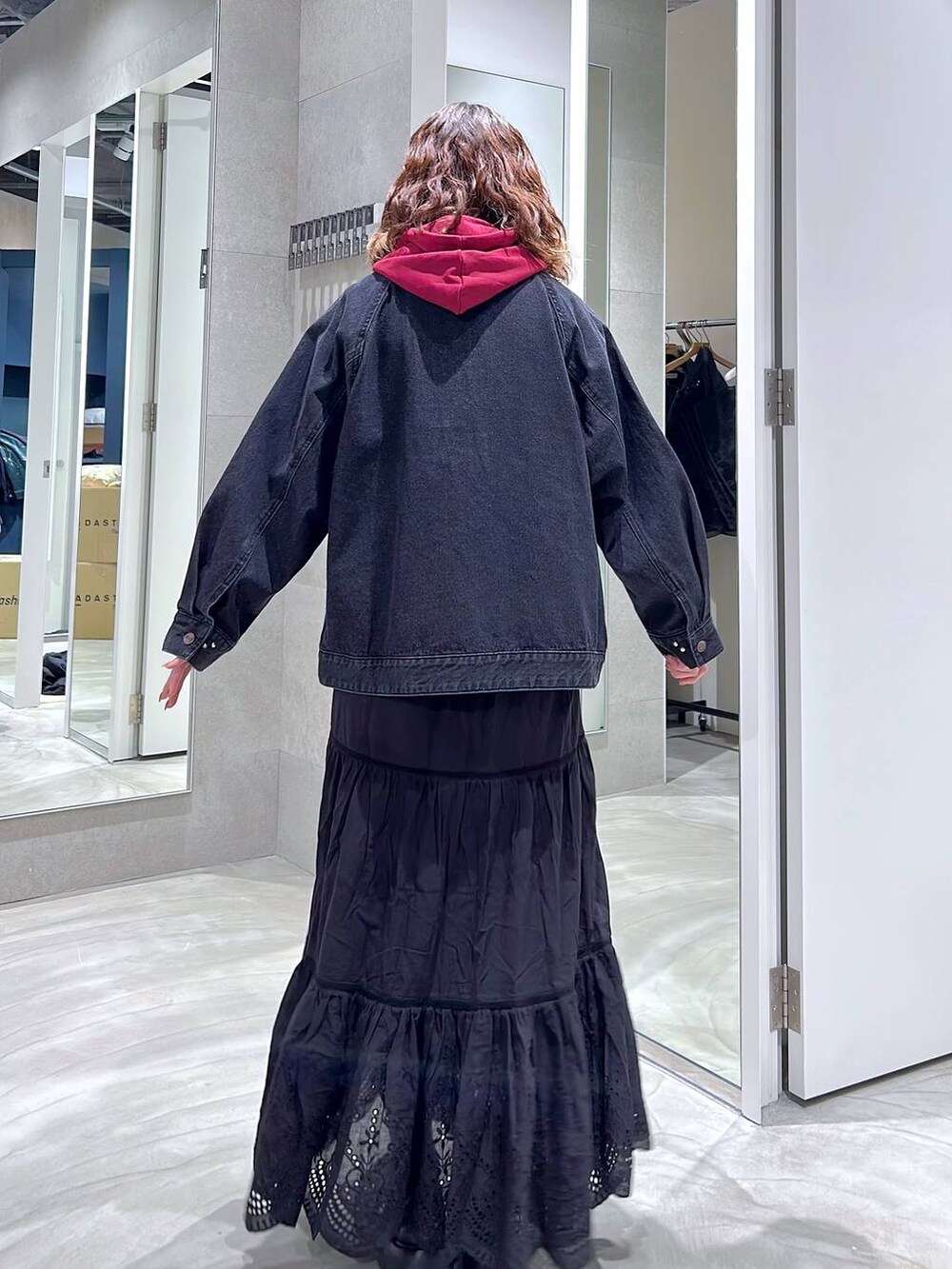 ブラック系のローファー、ブラック系のブルゾン、レッド系のパーカーを着用したレディースの秋コーディネートの5枚目の写真