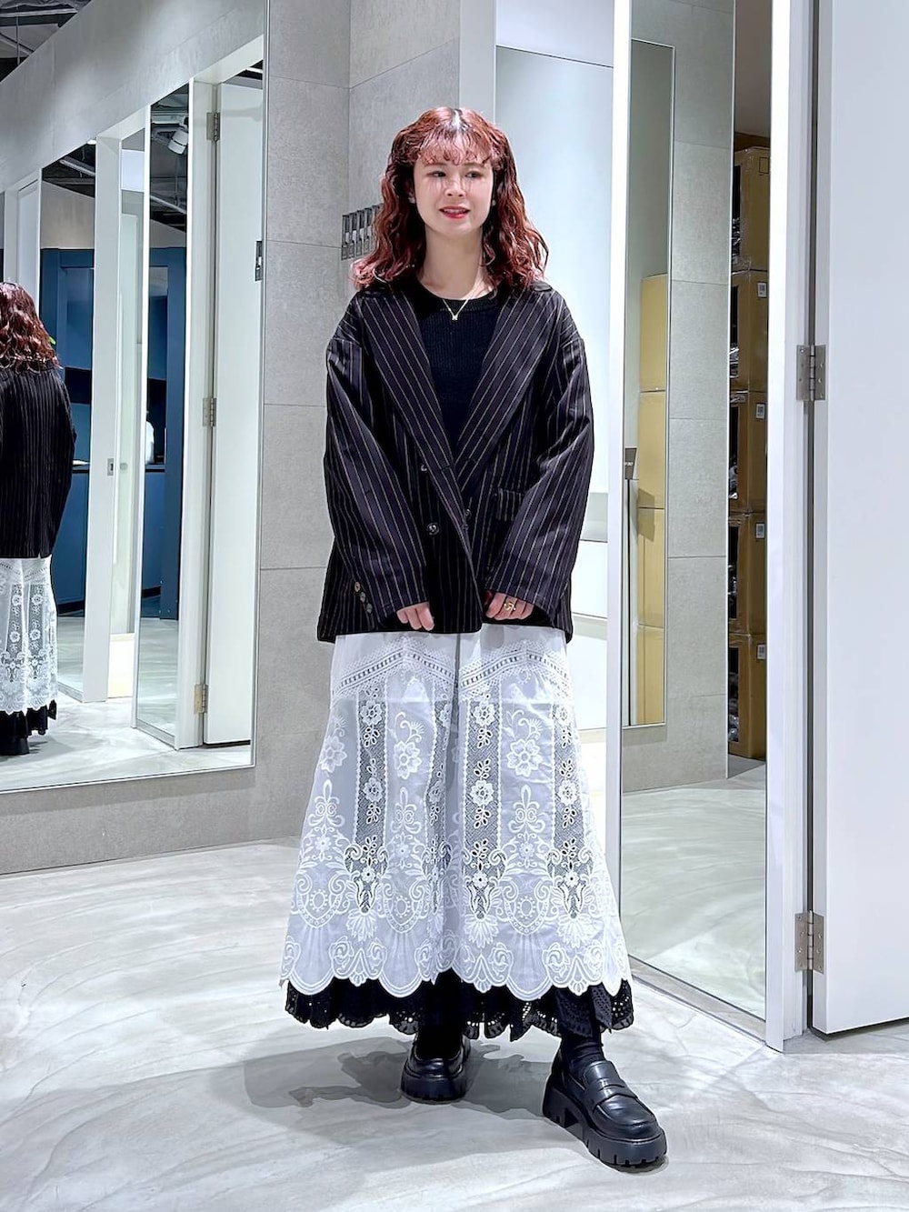 ブラック系のローファー、ブラック系のテーラードジャケット、ホワイト系のスカートを着用したレディースの冬コーディネートの4枚目の写真