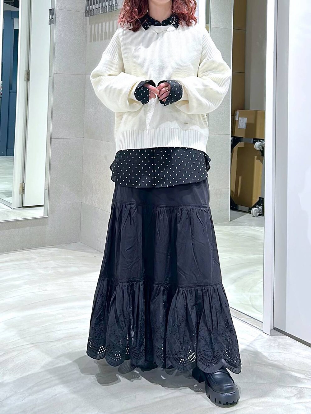 ブラック系のローファー、ブラック系のスカート、ホワイト系のニット/セーターを着用したレディースの冬コーディネートの2枚目の写真